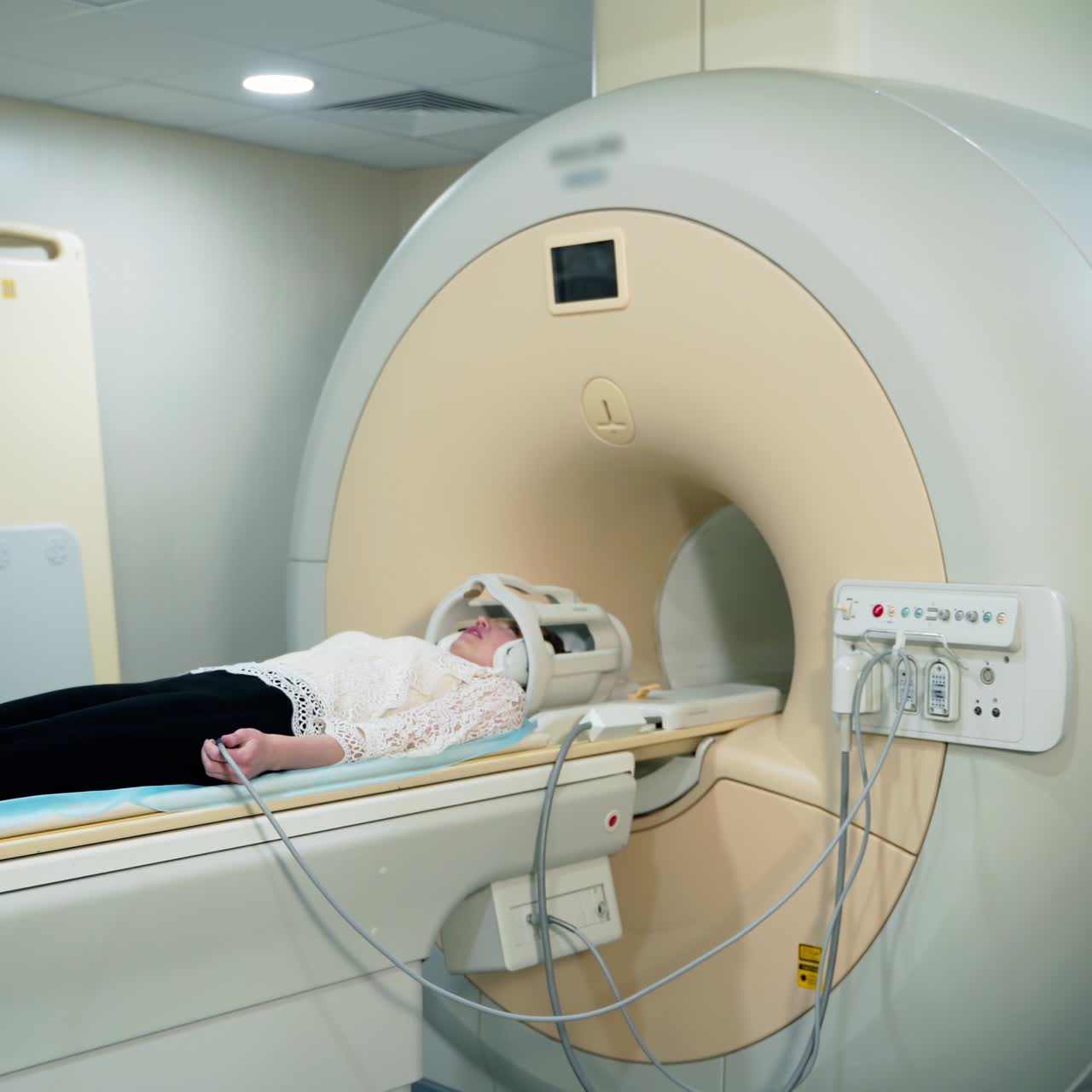 Patient in a hospital MRI scanner. Woman lays in Magnetic resonance image device. Woman patient is doing tomographic scanning in clinic.