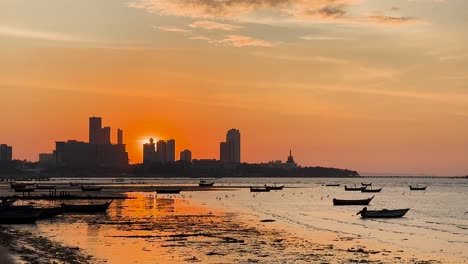 vista del atardecer con barcos y el horizonte de la ciudad