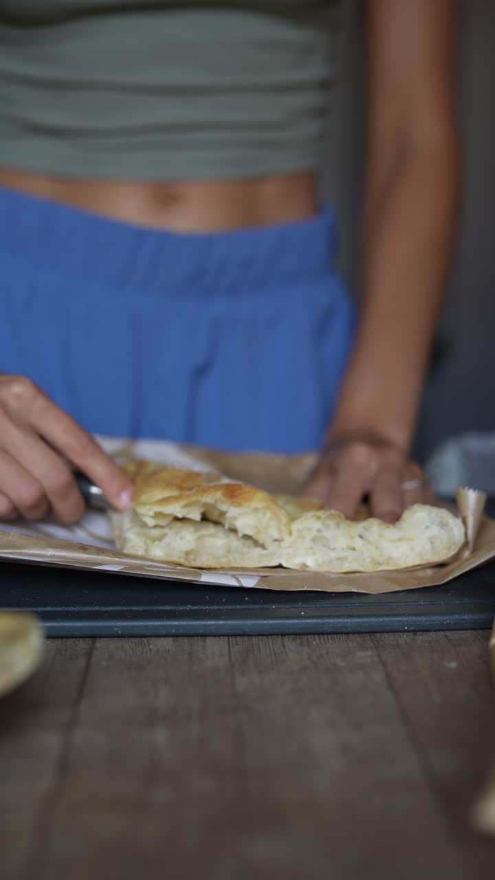 mujer cortando un pedazo de pan casero