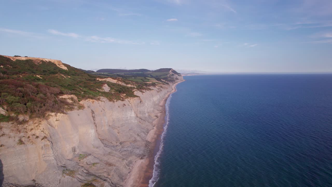 Høyt droneopptak som beveger seg bakover langs klippene på Jurassic Coast en sommerdag, Dorset, Storbritannia