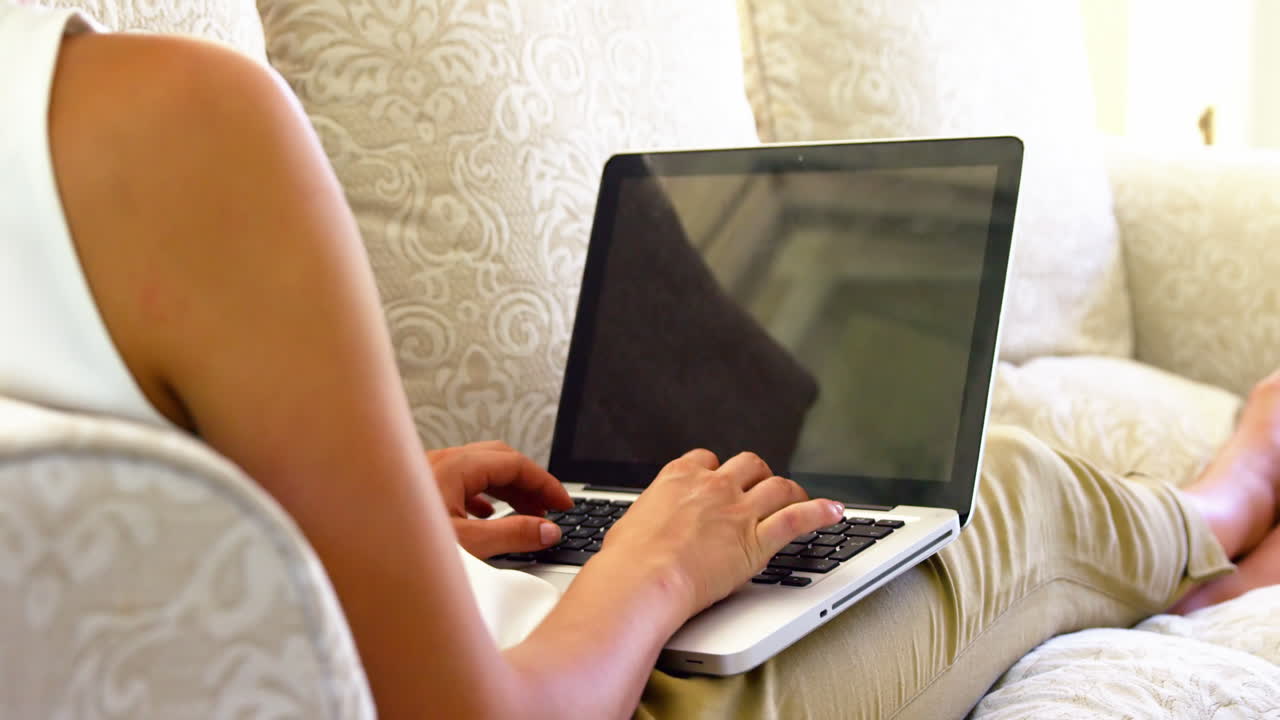 Women typing on a laptop in a sofa