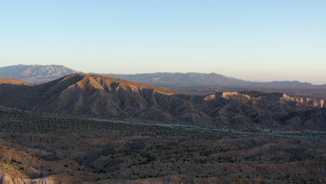 Flying-Over-Badlands-Towards-Mountains,-Aerial