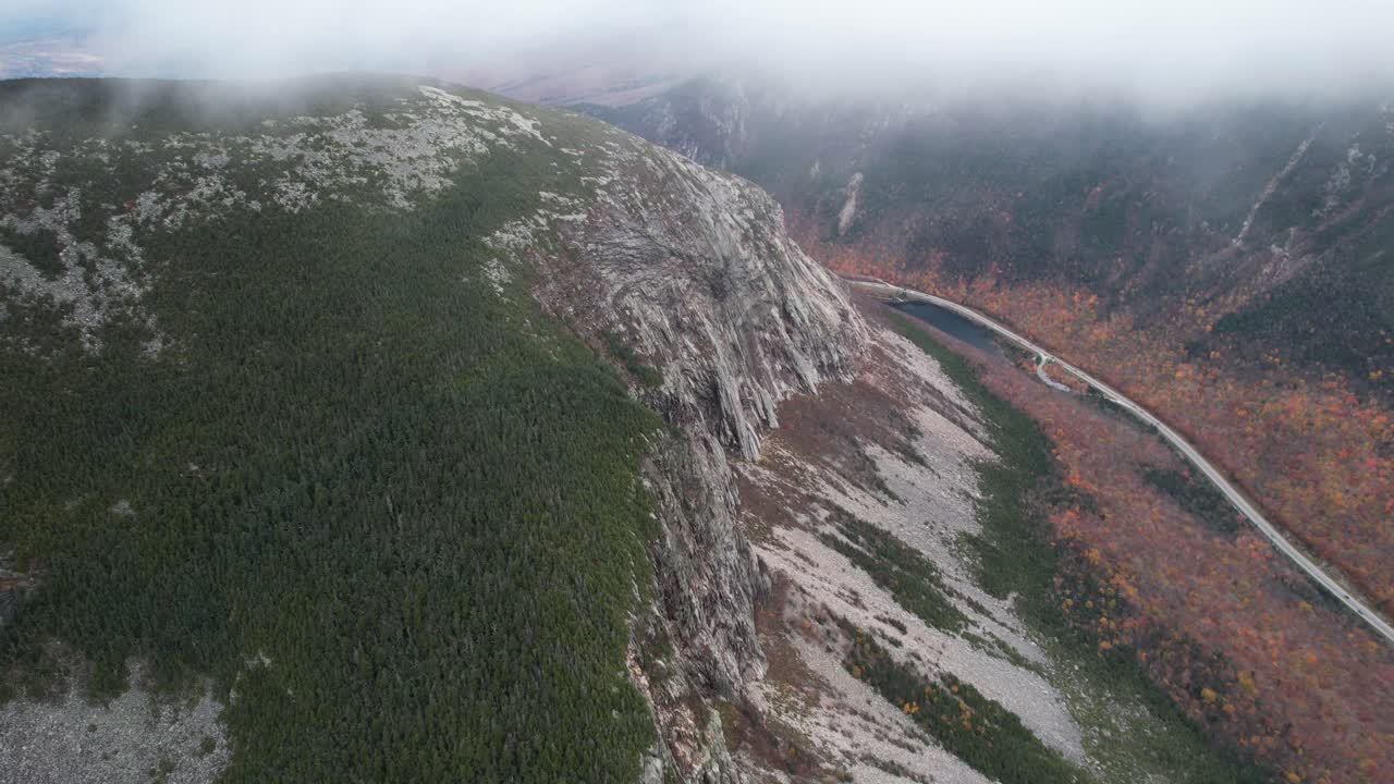 vista aérea del paso de montaña del cañón, camino bajo colinas y nubes, disparo de drones