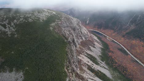 aerial view of canyon mountain pass, road under hills and clouds, drone shot