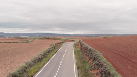 Vista-Aérea-De-Una-Carretera-Giratoria-Con-Un-Coche-Que-Pasa