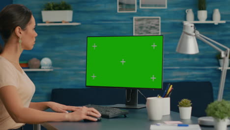 mujer trabajando en una computadora personal con un simulacro de pantalla verde pantalla clave de croma