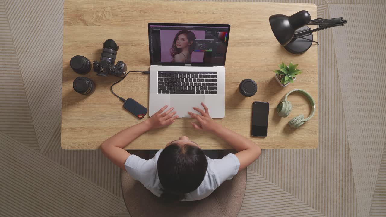 Top View Of Asian Woman Editor Having A Backache While Sitting In The Workspace Using A Laptop Next To The Camera Editing Photo Of A Woman At Home