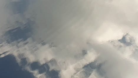 un cielo azul con nubes que se reflejan en la superficie del agua