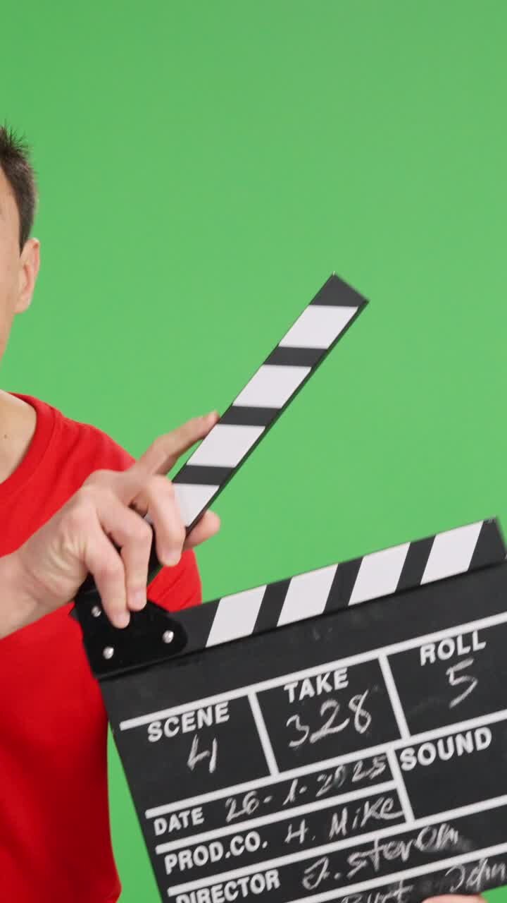 Filmmaker using clapperboard on green screen background