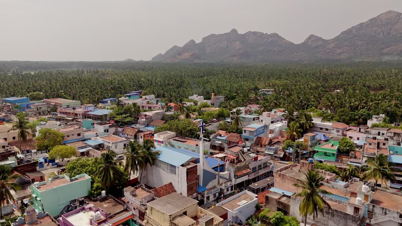 Drone flyby of local church based in a suburb locality with rugged mountains at background.