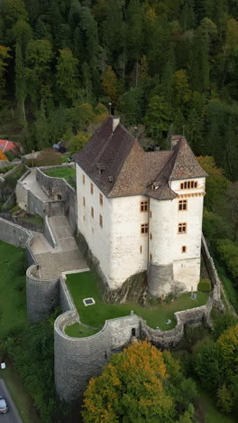 vertical, aerial: crane down drone shot of valangin castle during the day in canton of neuchatel, switzerland