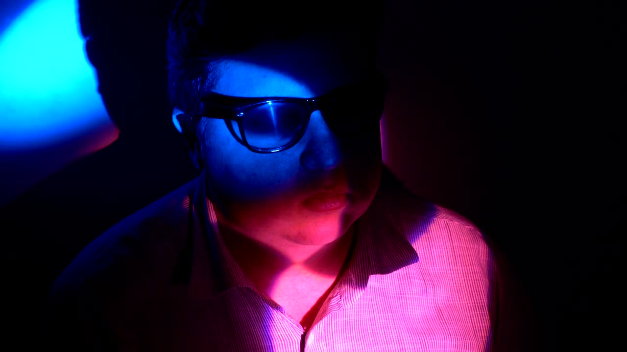 retrato de un hombre gordo en un haz de luz multicolor.