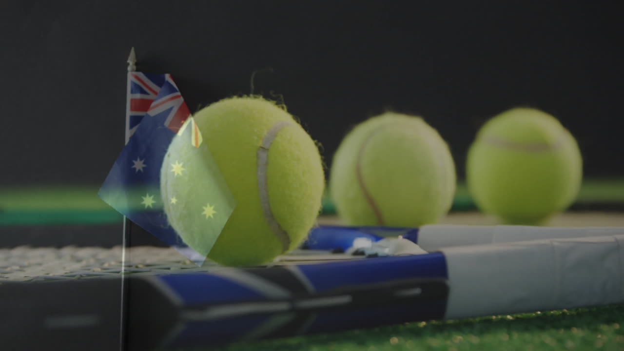 Yellow tennis ball resting on blue racket strings while Australian flag standing on green court