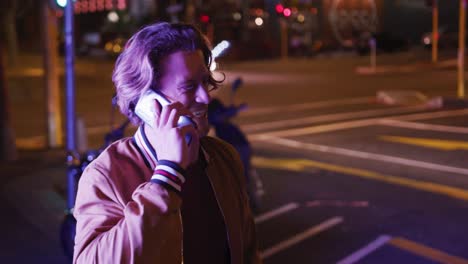 caucasian male smiling and talking on the phone in the evening