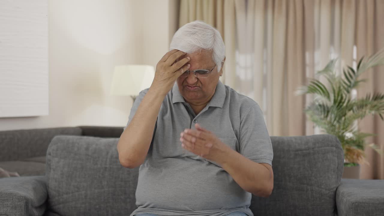 Sjuk indisk äldre man som lider av huvudvärk