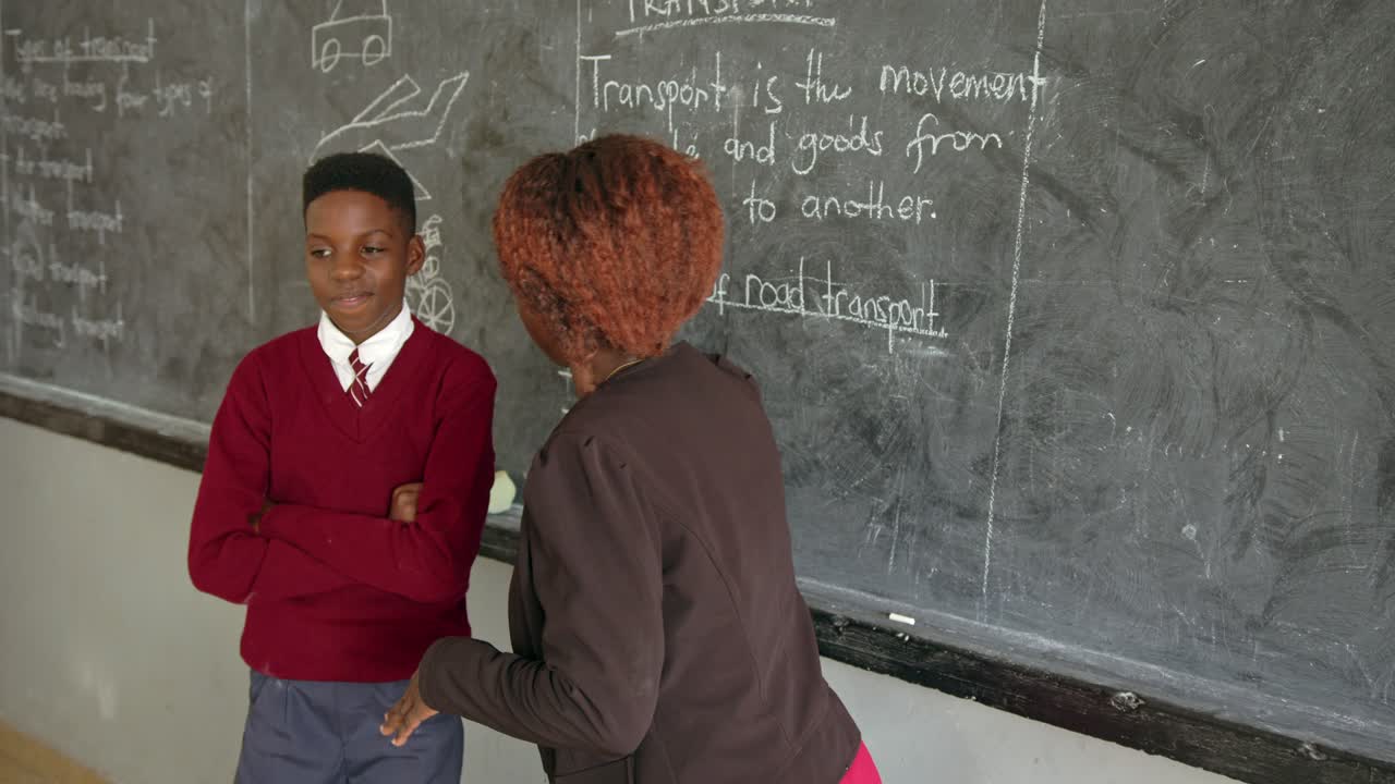 Male Student And Teacher In Classroom In An African School In Uganda