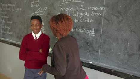 male student and teacher in classroom in an african school in uganda