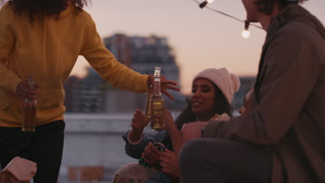 happy rooftop party friends drinking alcohol having fun on weekend social gathering sitting on couch chatting enjoying hanging out together at sunset