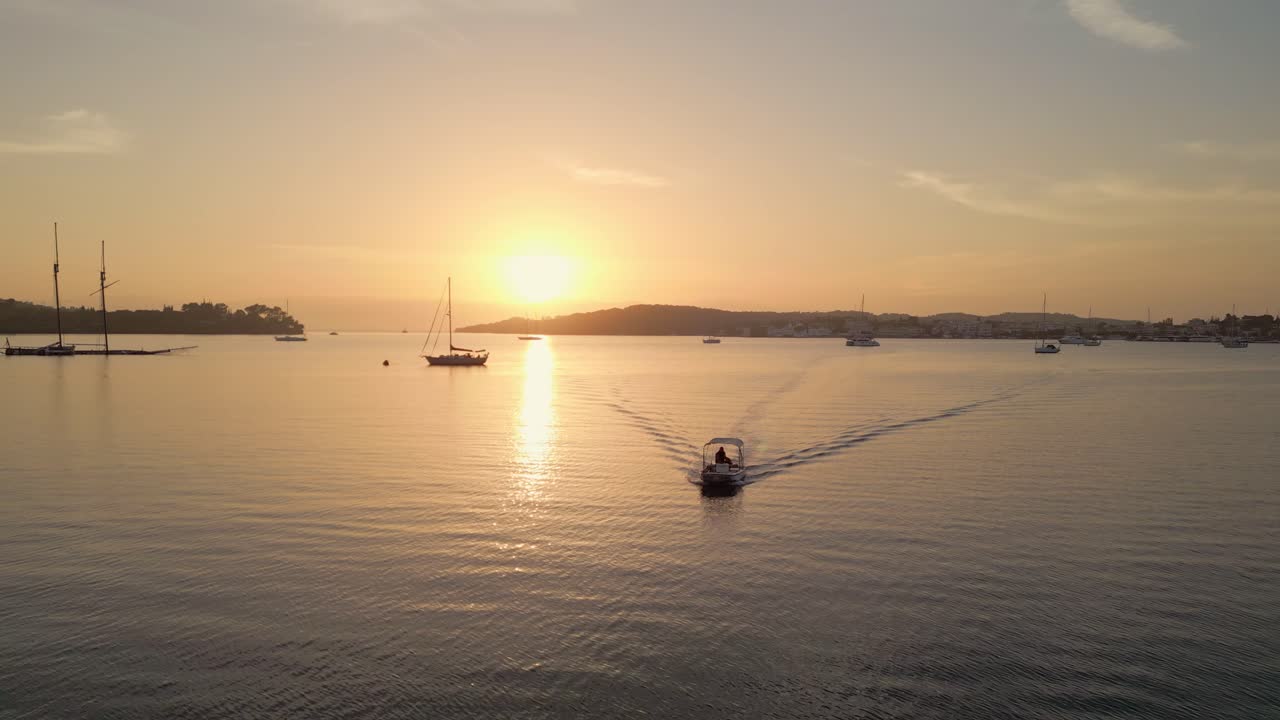 pequeño barco a motor navegando en la bahía del puerto en porto heli, grecia al atardecer
