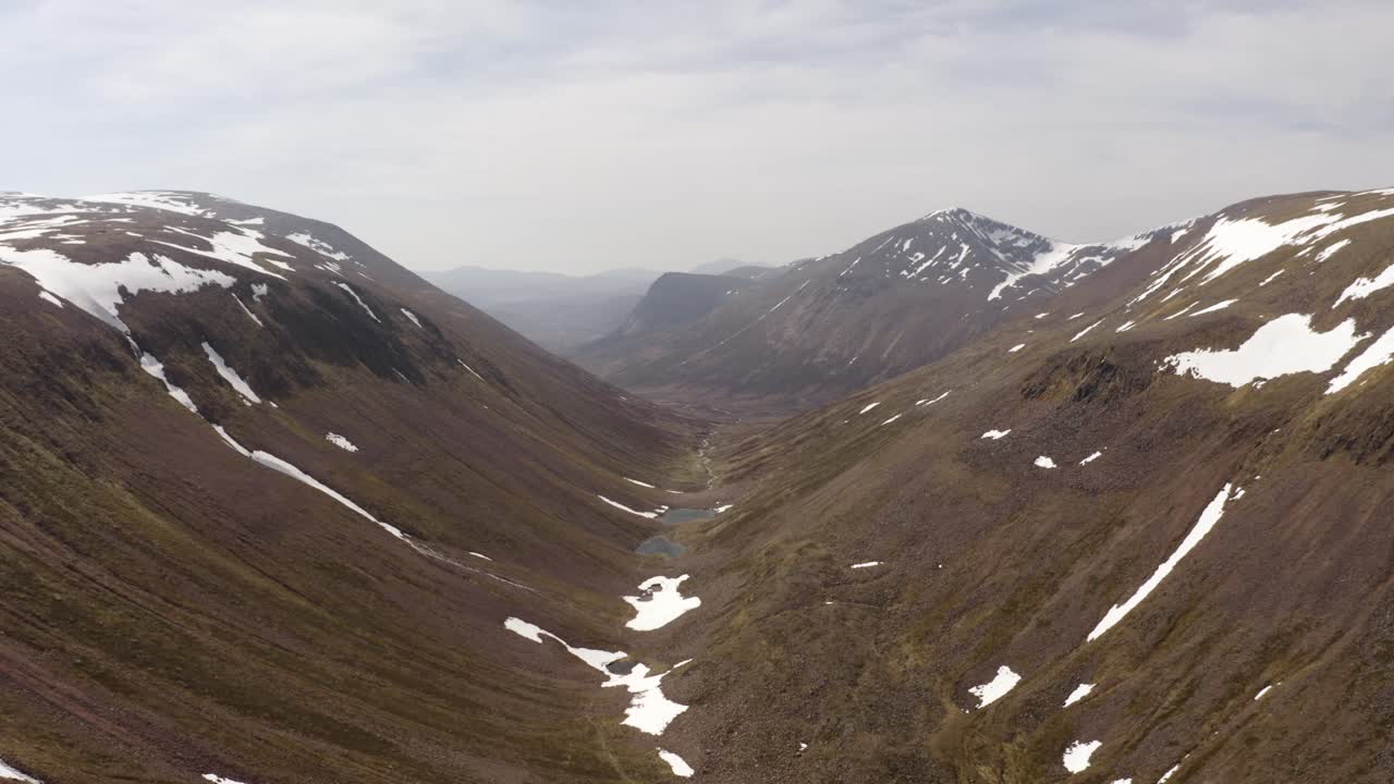 valle de la montaña de escocia con tiro de empuje de drones de nieve
