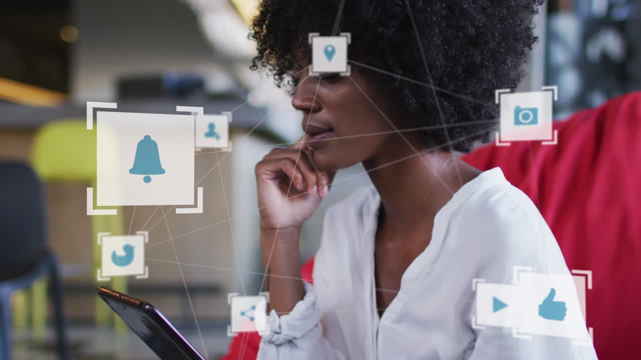 Network of digital icons against african american woman using digital tablet at office