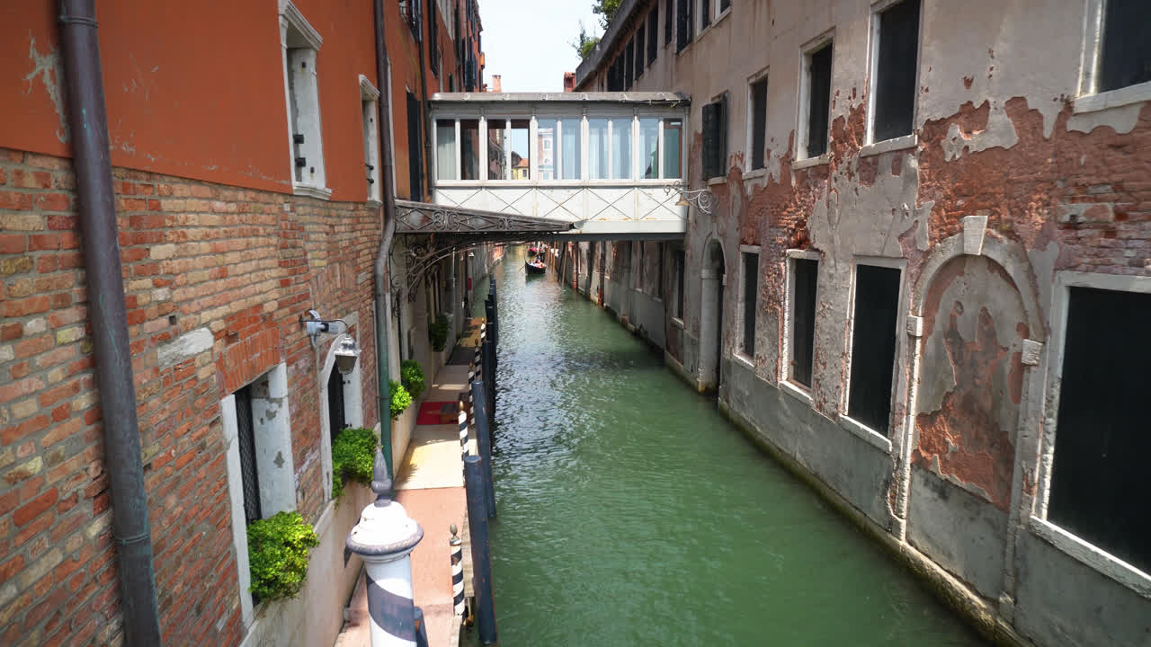 pequeño puente que une edificios residenciales por el gran canal en venecia, italia
