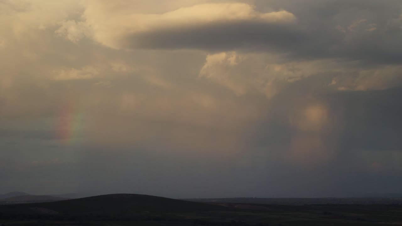 Cloud rainbow on a sunset over the spanish hills
