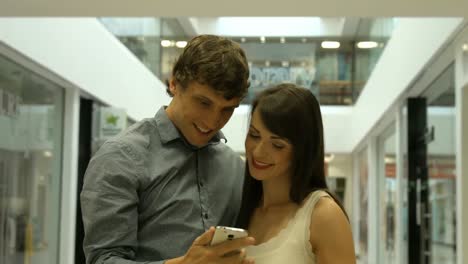 una pareja sonriente tomando una selfie.