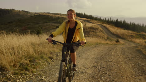 Ciclista-En-Bicicleta-Deportiva-En-Las-Montañas.-Mujer-Sonriente,-Andar-En-Bicicleta-De-Montaña