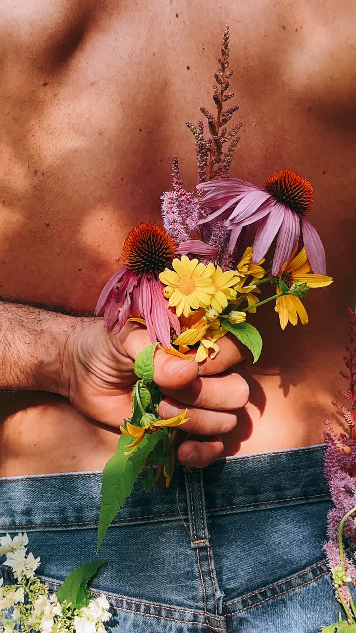 hombre sosteniendo un ramo de flores detrás de su espalda