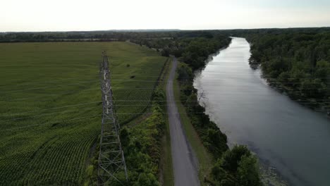 electricity power lines going across river water in countryside, drone aerial