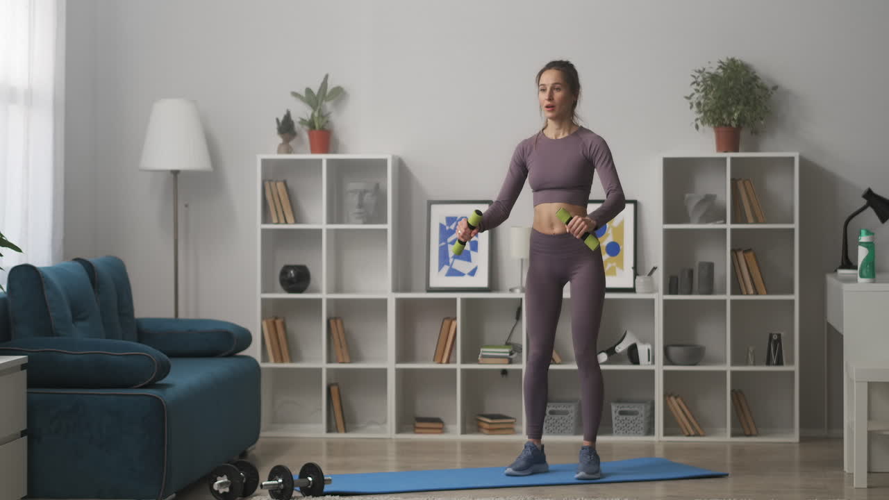 hermosa mujer está entrenando con pesas en casa preocupándose por la salud y la buena condición física actividad física y deportiva toma completa