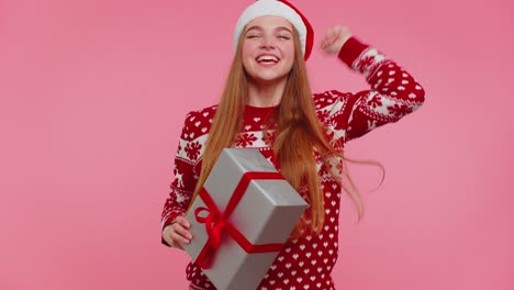 cheerful girl in christmas santa sweater getting present gift box expressing amazement happiness