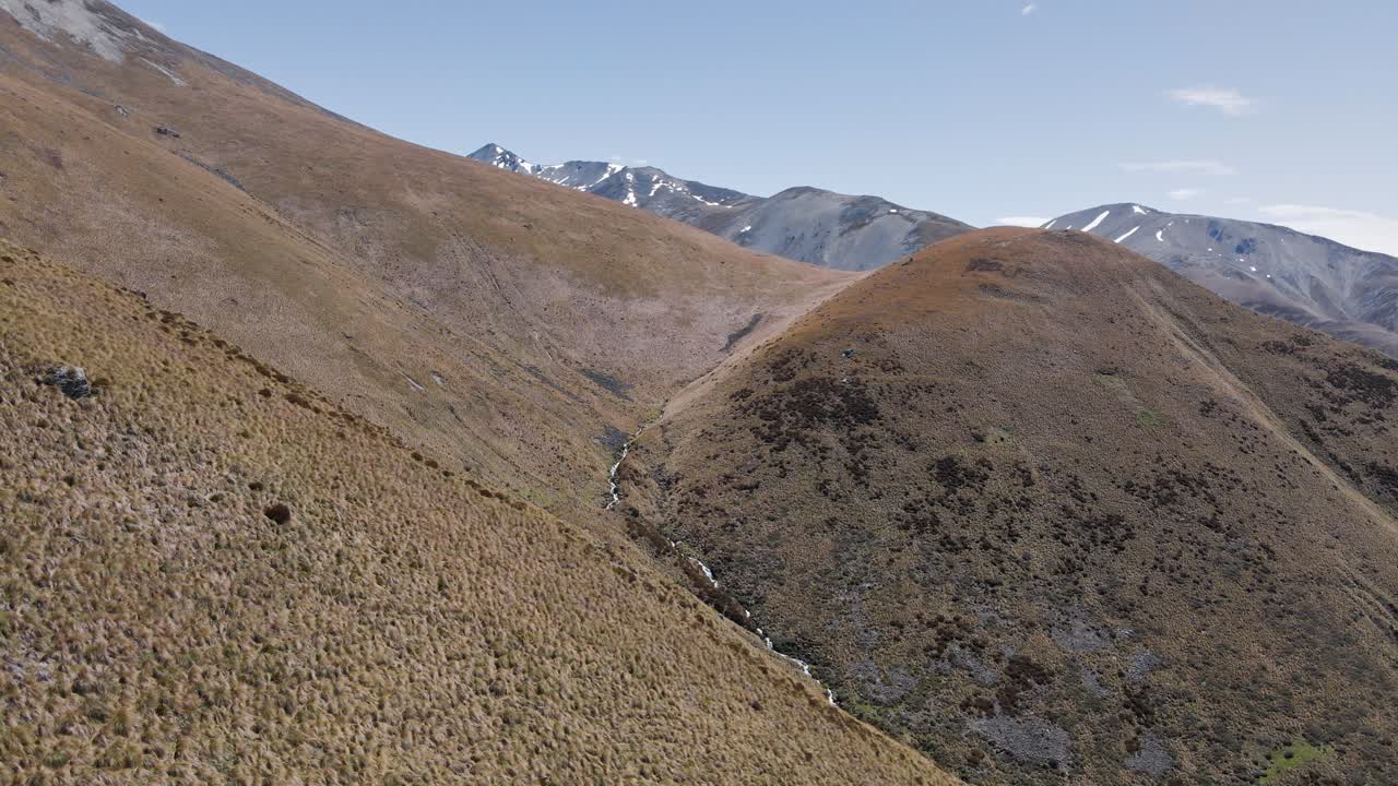 pequeño río de nieve derretida que fluye desde la cima de montañas secas en nueva zelanda
