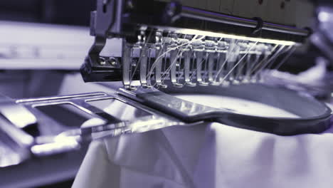 close-up of an embroidery machine working on white fabric