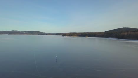 a person in solitude ice-skating on a big lake