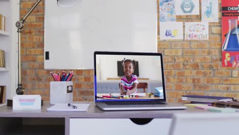 Vista-De-Cámara-Web-De-Una-Colegiala-Afroamericana-En-Videollamada-En-Una-Computadora-Portátil-En-La-Mesa-De-La-Escuela