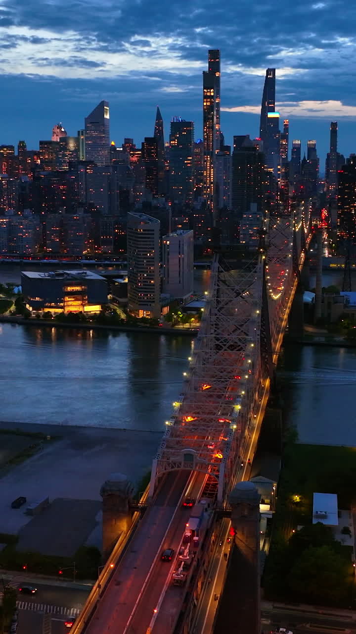 Stunning cityscape of New York in the lights. Spectacular Queensboro Bridge over East River at the backdrop of skyscrapers at night. Vertical video
