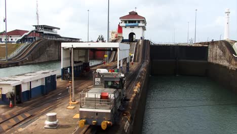 locomotora eléctrica tirando lentamente del barco hacia la primera cámara en las esclusas de gatun, canal de panamá