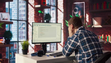 hombre en casa estirando la espalda mientras mira ui en la pantalla de la pc, sintiéndose fatigado