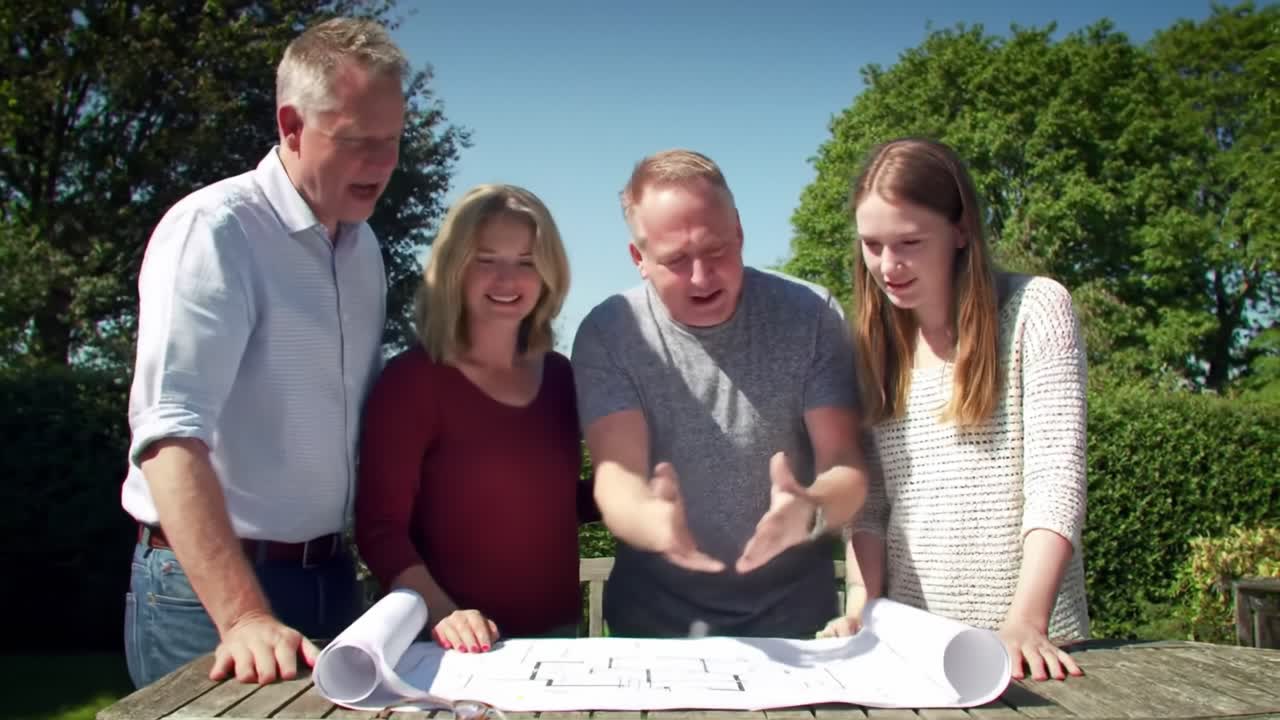 Four family members gather around a table to review architectural plans for their house renovation. They share ideas and engage enthusiastically while enjoying a sunny day.