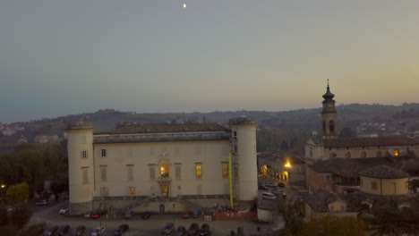 Vista-Aérea-De-La-Fachada-Del-Castillo-En-Costigliole-D&#39;asti-Al-Anochecer,-Italia