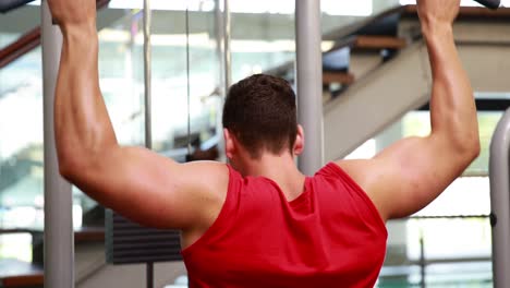 Fit-man-using-the-weights-machine-for-his-arms