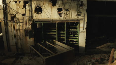 Old-destroyed-brick-wall-with-green-electrical-panel-fuse-box-in-abandoned-collapsed-factory