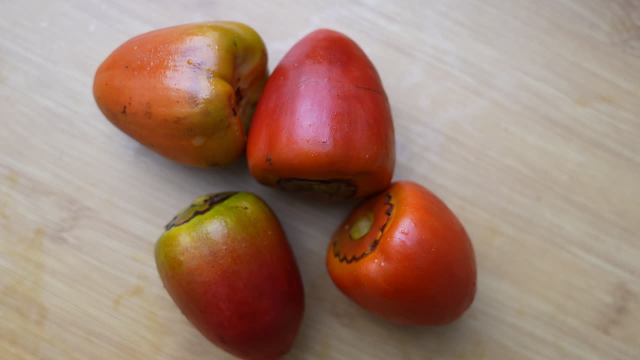 Foto em close-up nítida de chontaduros maduros sobre uma superfície de madeira. Captura as cores vibrantes e as texturas suaves, perfeito para mostrar os ingredientes da culinária colombiana