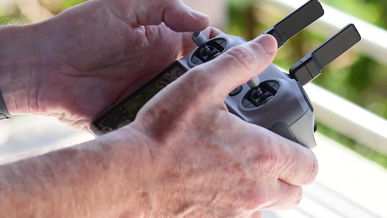 Visualizzazione dettagliata di mani che utilizzano joystick su un controller wireless con uno sfondo sfocato