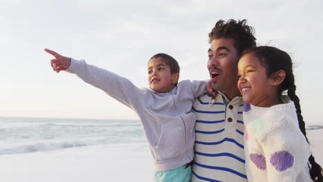 Happy-hispanic-father,-daughter-and-son-looking-at-sunset-on-beach