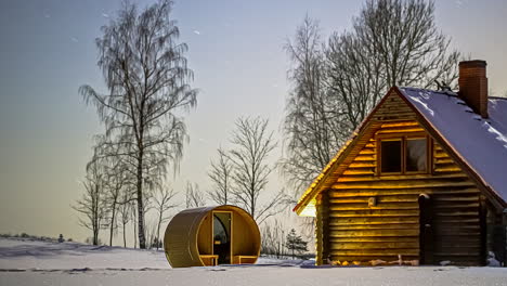 timelapse nocturno sobre una sauna de bañera y un chalet de madera cubierto de nieve, en un campo de invierno salvaje