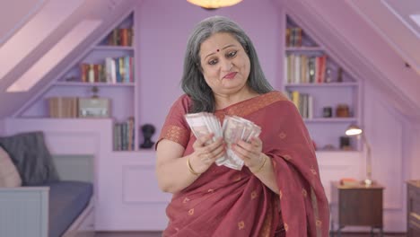una anciana india alegre contando dinero.