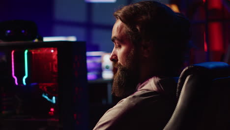 man playing video games on gaming pc at computer desk during leisure time